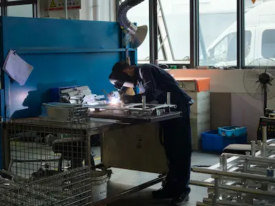 MIG/MAG welding station — active welding with protective gear